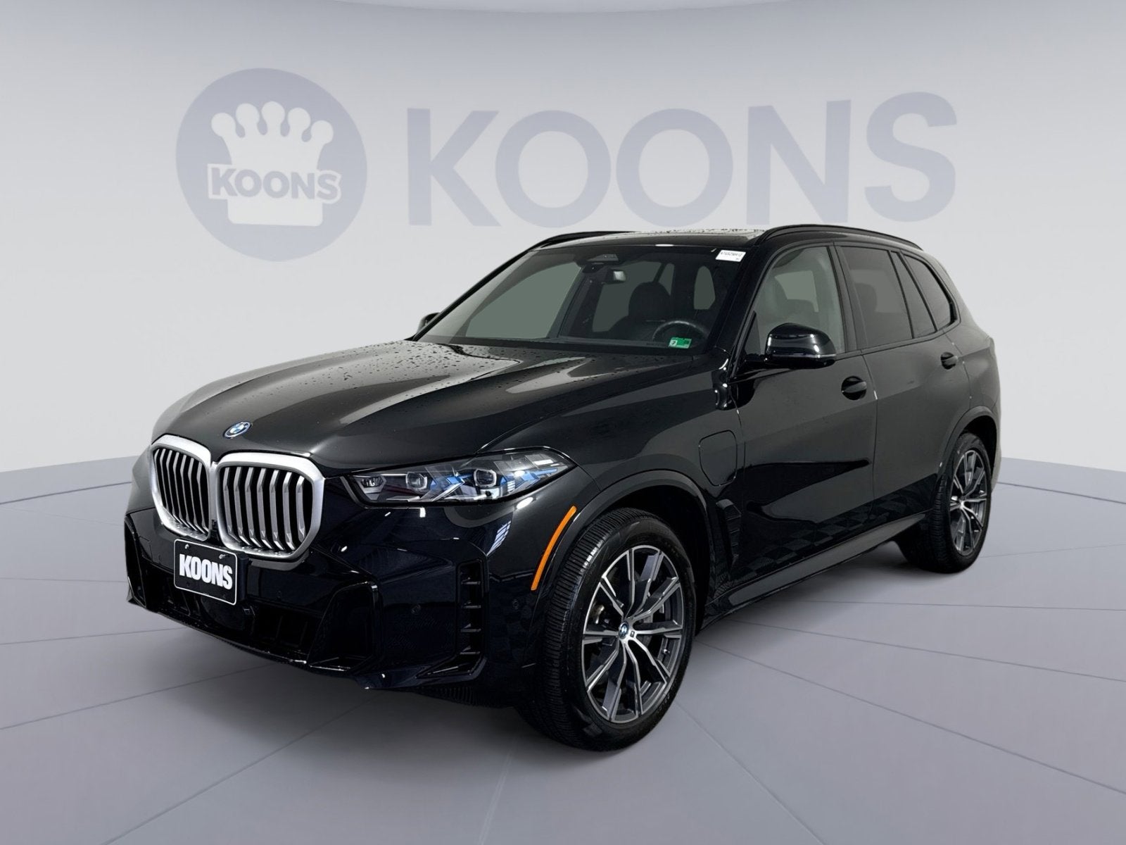 2025 BMW X5 xDrive50e in Black Sapphire Metallic — front three-quarter view